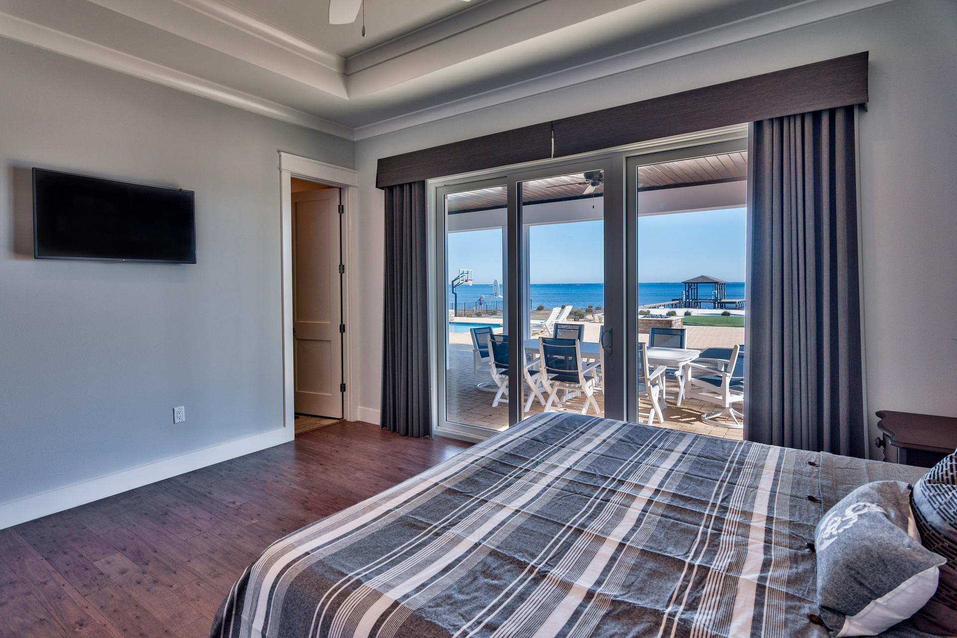1591 Driftwood Point Road Santa Rosa Beach, FL 32459 - Photo 29 of 50 a bedroom with a large bed and a flat tv screen next to a window