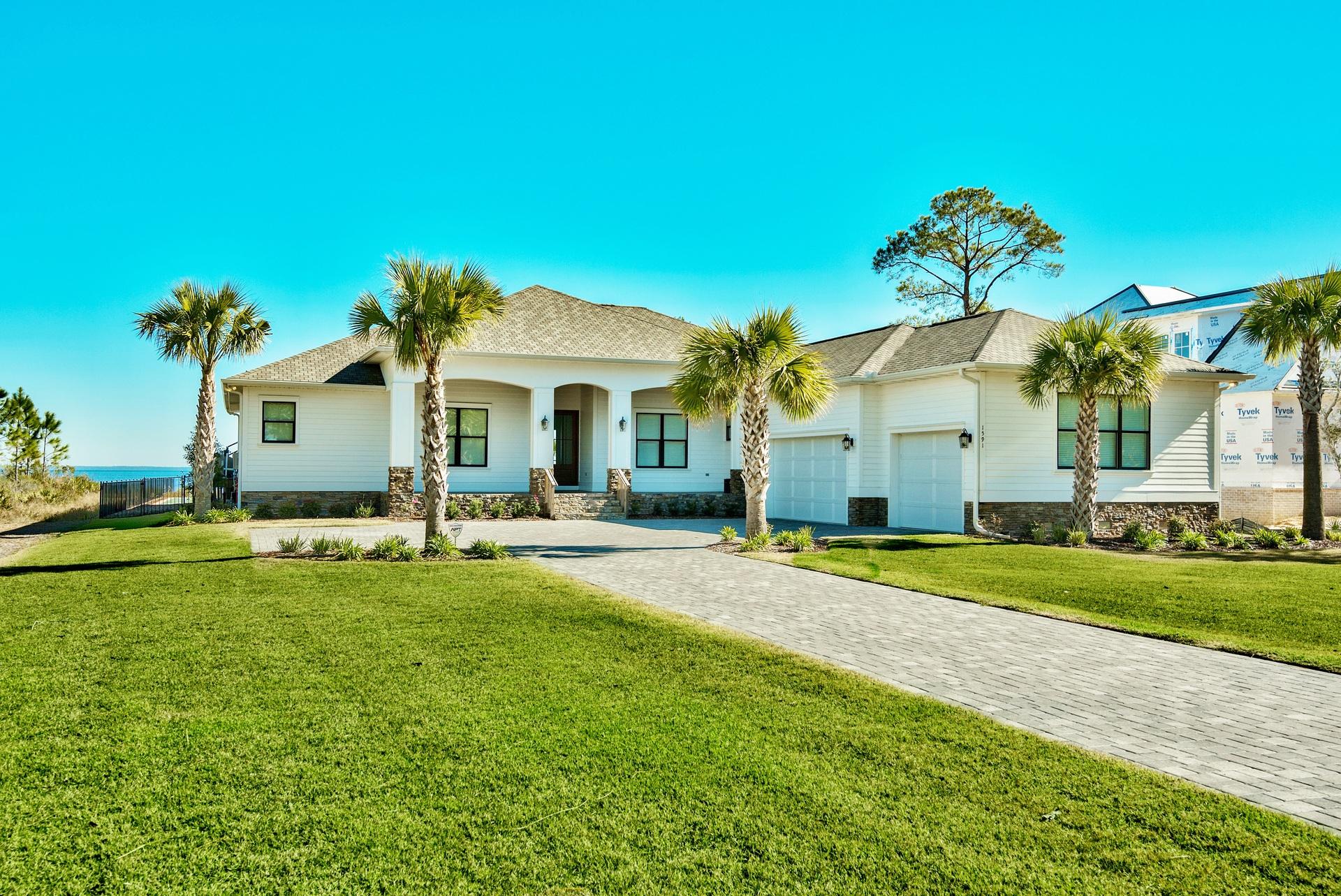 1591 Driftwood Point Road Santa Rosa Beach, FL 32459 - Photo 6 of 50 a view of a white house with a swimming pool and a big yard
