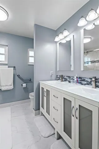 a spacious bathroom with a double vanity sink mirror and toilet