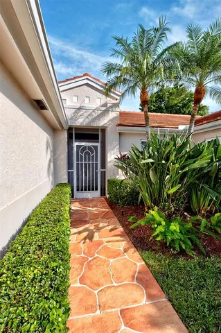 a view of a house with potted plants and a pathway