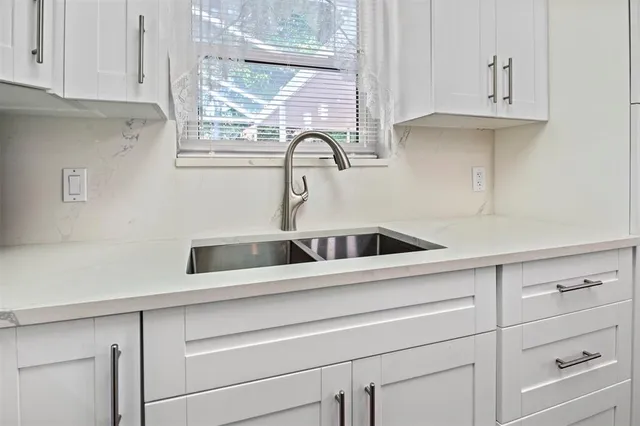 a close view of a kitchen sink and cabinets