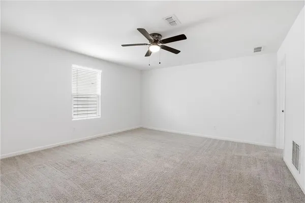 an empty room with a window and a fan