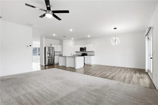 a view of kitchen with refrigerator microwave and stove