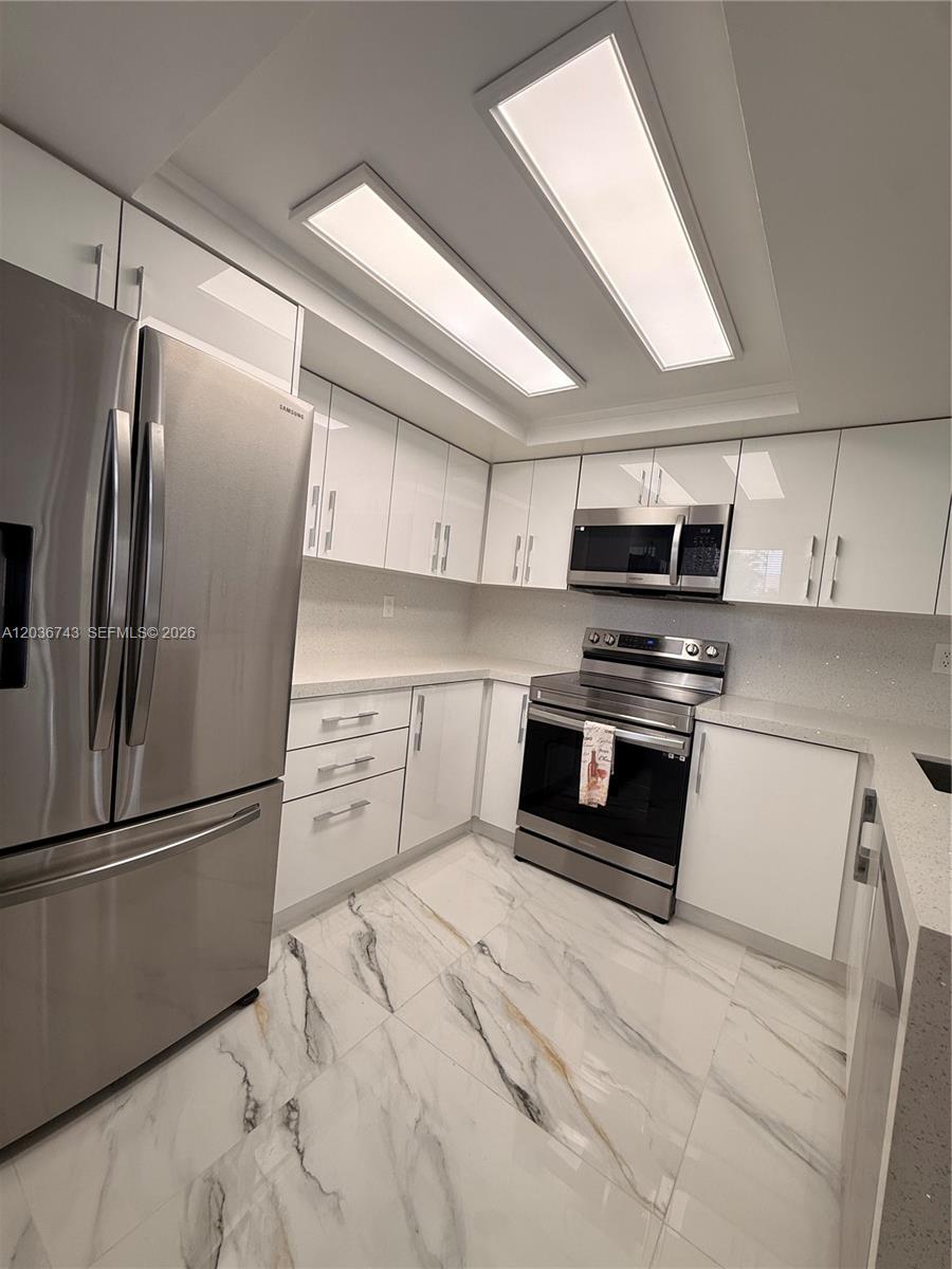 10875 Northwest 7th Street, Unit 1136 Miami, FL 33172 - Photo 10 of 25 a kitchen with stainless steel appliances and refrigerator