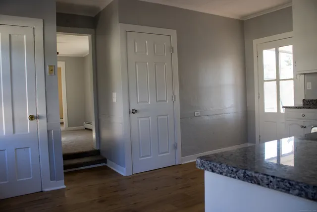 a view of a hallway with wooden floor and closet area