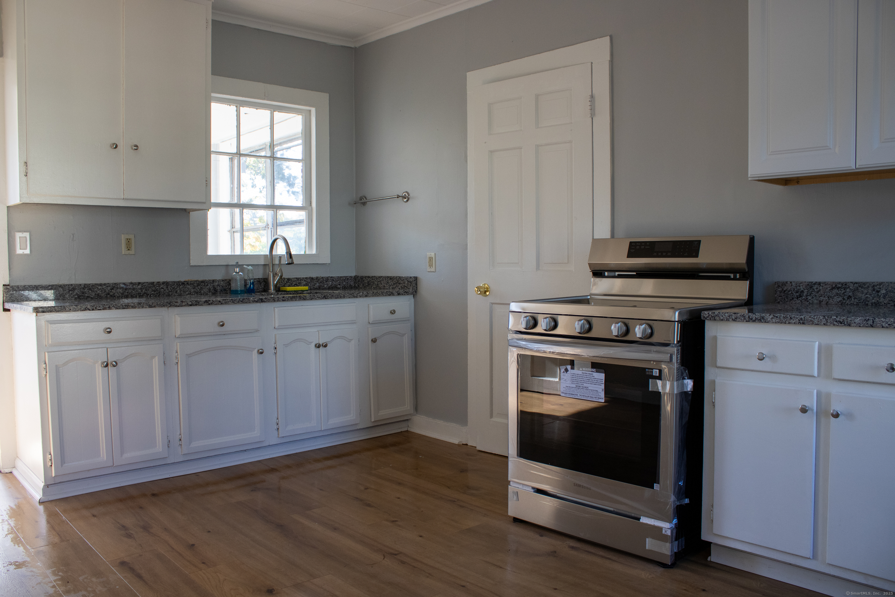 34 Fair Street Wallingford, CT 06492 - Photo 6 of 22 a kitchen with granite countertop a stove a sink and wooden cabinets