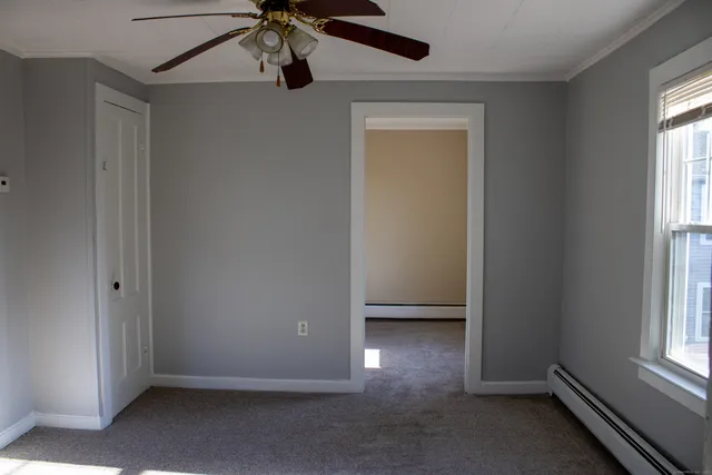 an empty room with windows and fan