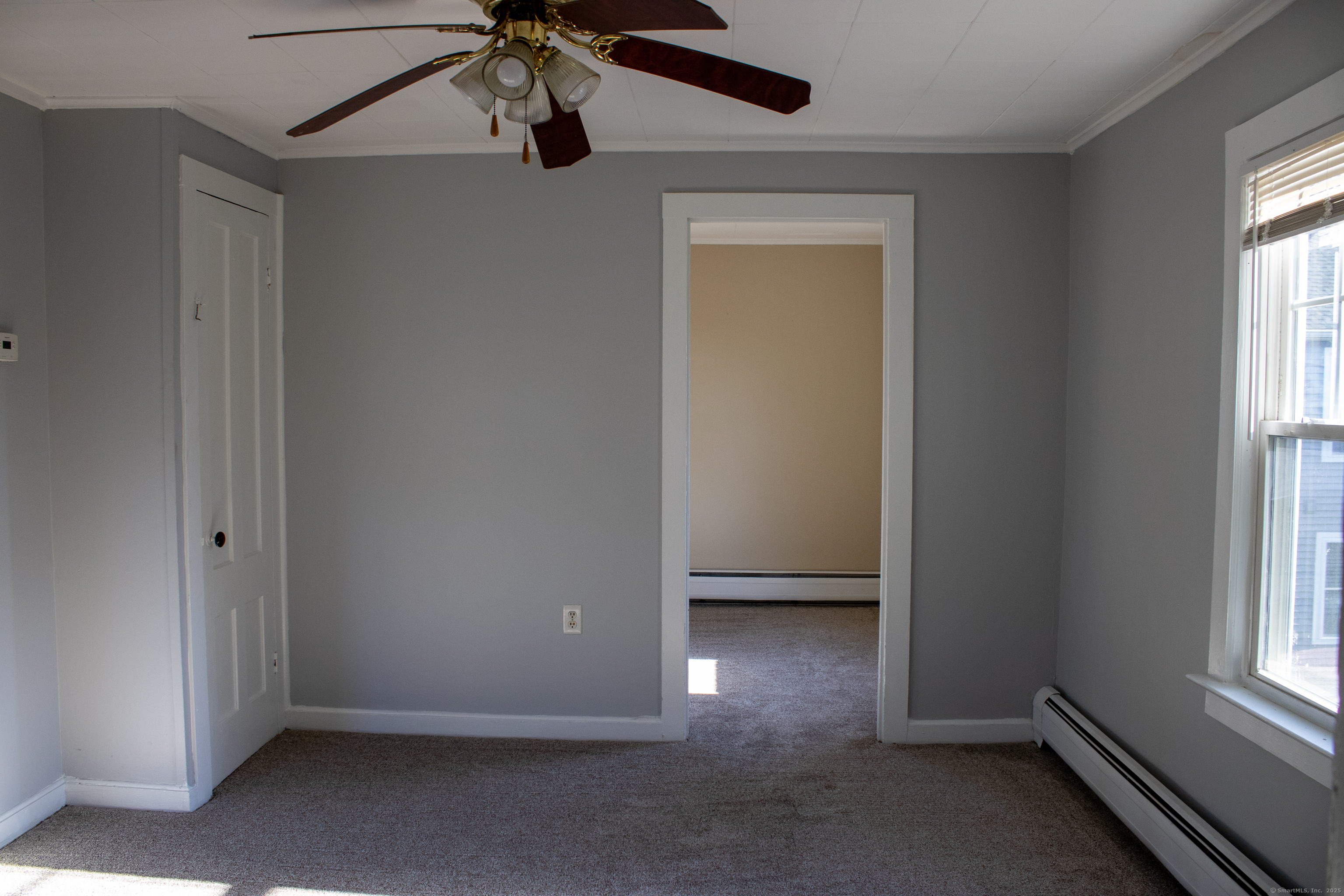 34 Fair Street Wallingford, CT 06492 - Photo 7 of 22 an empty room with windows and fan