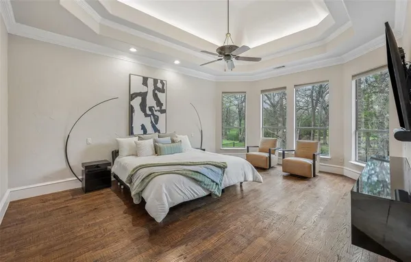 a bedroom with bed and flat tv with wooden floor