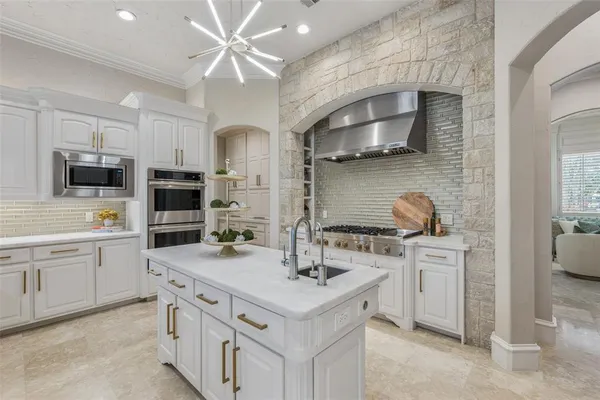 a kitchen with stainless steel appliances white cabinets and a sink