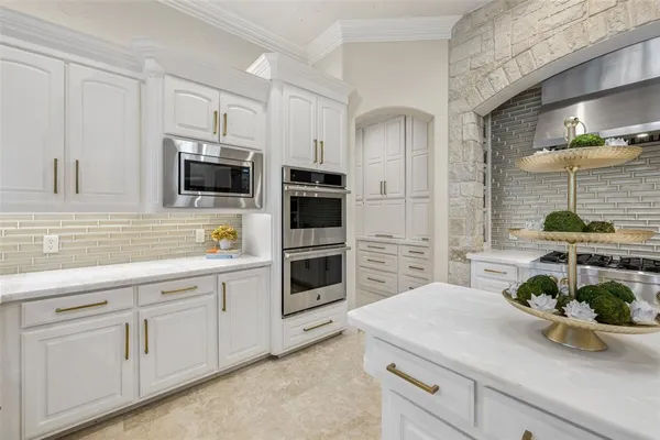 a kitchen with white cabinets and sink