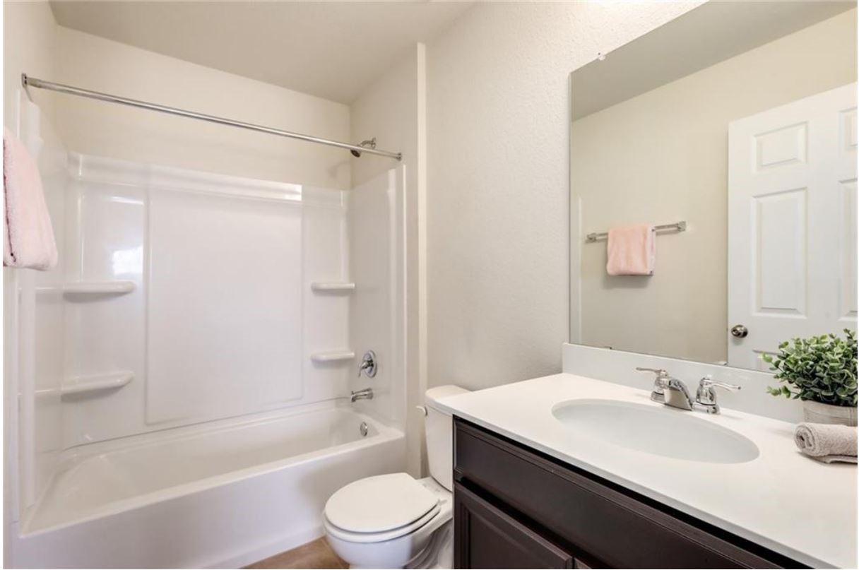 169 Marcheeta Way Leander, TX 78641 - Photo 19 of 30 a bathroom with a granite countertop sink toilet and shower