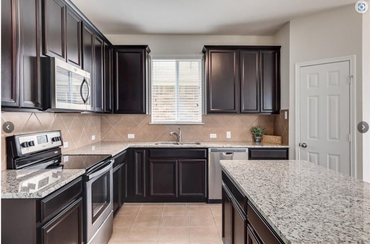169 Marcheeta Way Leander, TX 78641 - Photo 3 of 30 a kitchen with stainless steel appliances granite countertop a sink stove microwave and cabinets