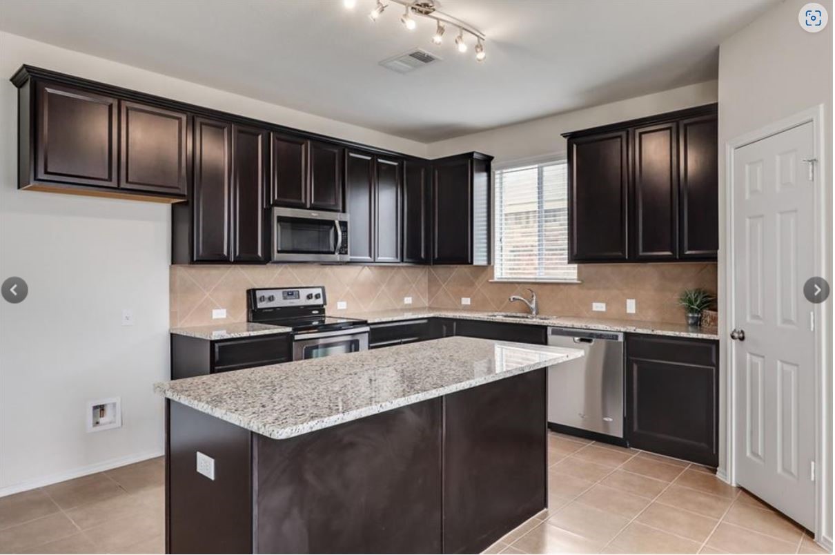 169 Marcheeta Way Leander, TX 78641 - Photo 7 of 30 a kitchen with granite countertop stainless steel appliances cabinets a sink and a counter space