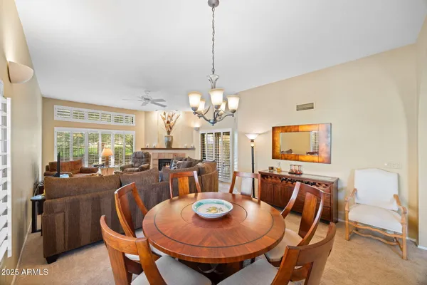 a view of a dining room with furniture a chandelier and wooden floor