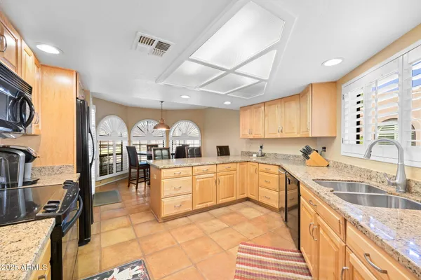 a kitchen with stainless steel appliances granite countertop a sink counter space cabinets and a stove