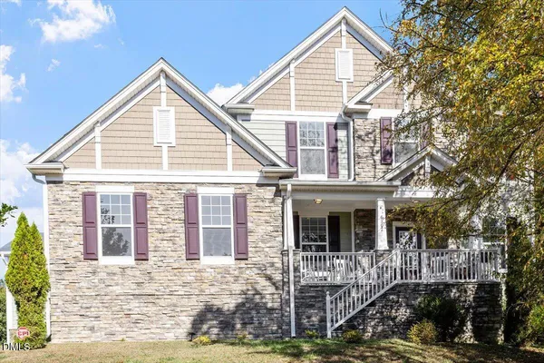 a view of a white house with large windows and a small yard
