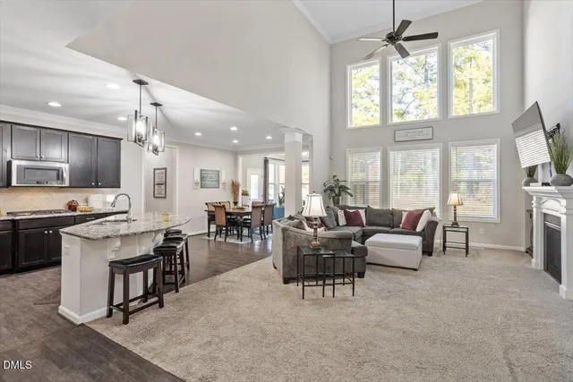 a living room with furniture a dining table and a large window