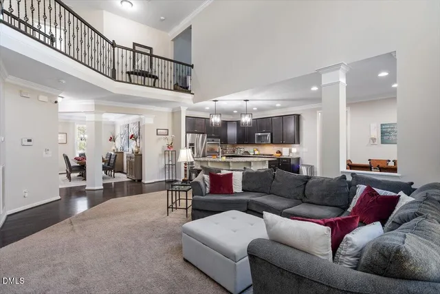 a living room with furniture kitchen view and a wooden floor