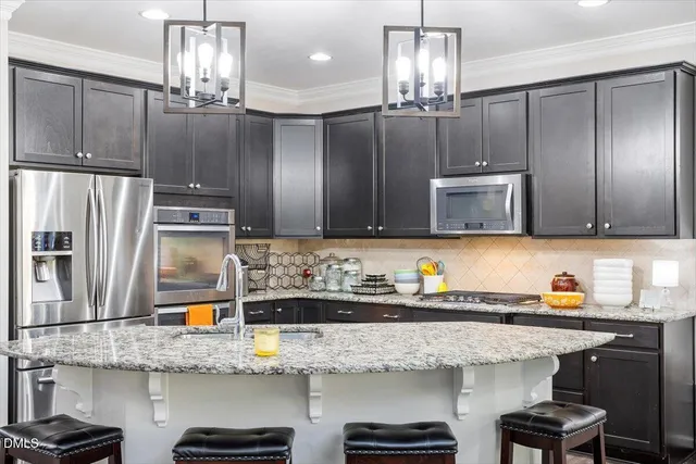 a kitchen with stainless steel appliances granite countertop a sink refrigerator and microwave