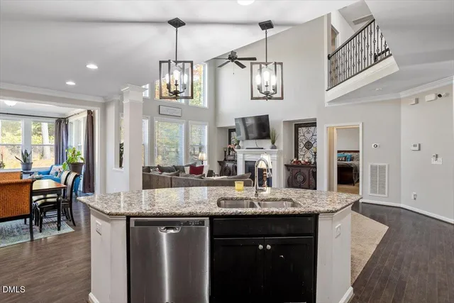 a kitchen with kitchen island granite countertop a sink cabinets and wooden floor