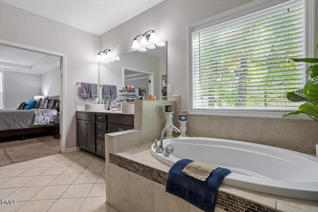 a bathroom with a tub sink and mirror