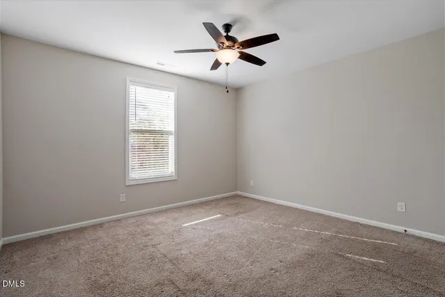 a view of an empty room and a ceiling fan