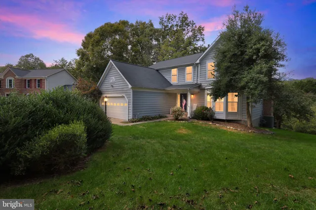 a front view of a house with a yard and trees