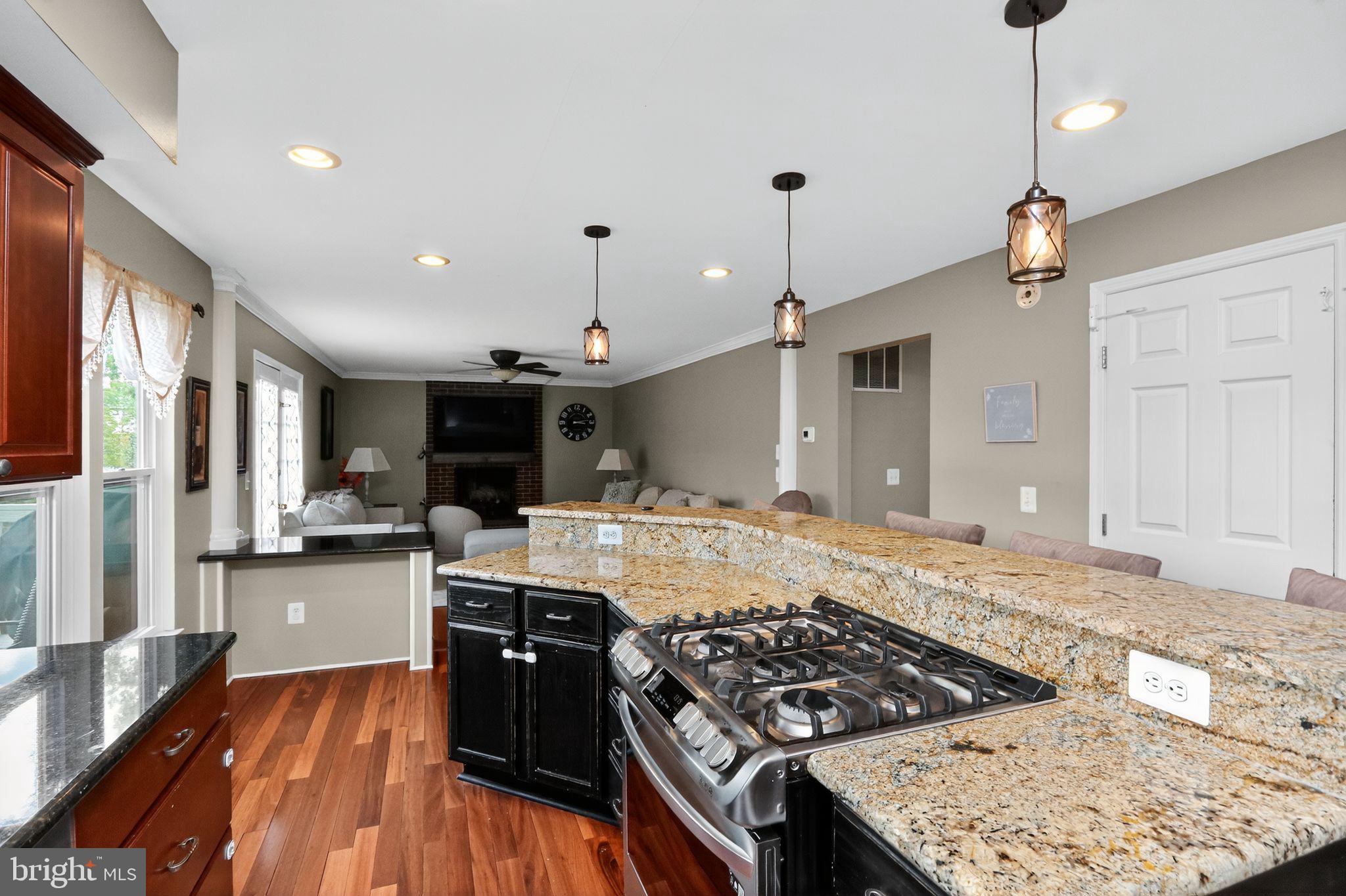 16601 Accolon Court Dumfries, VA 22025 - Photo 7 of 34 a kitchen with stainless steel appliances granite countertop a stove and a wooden floors