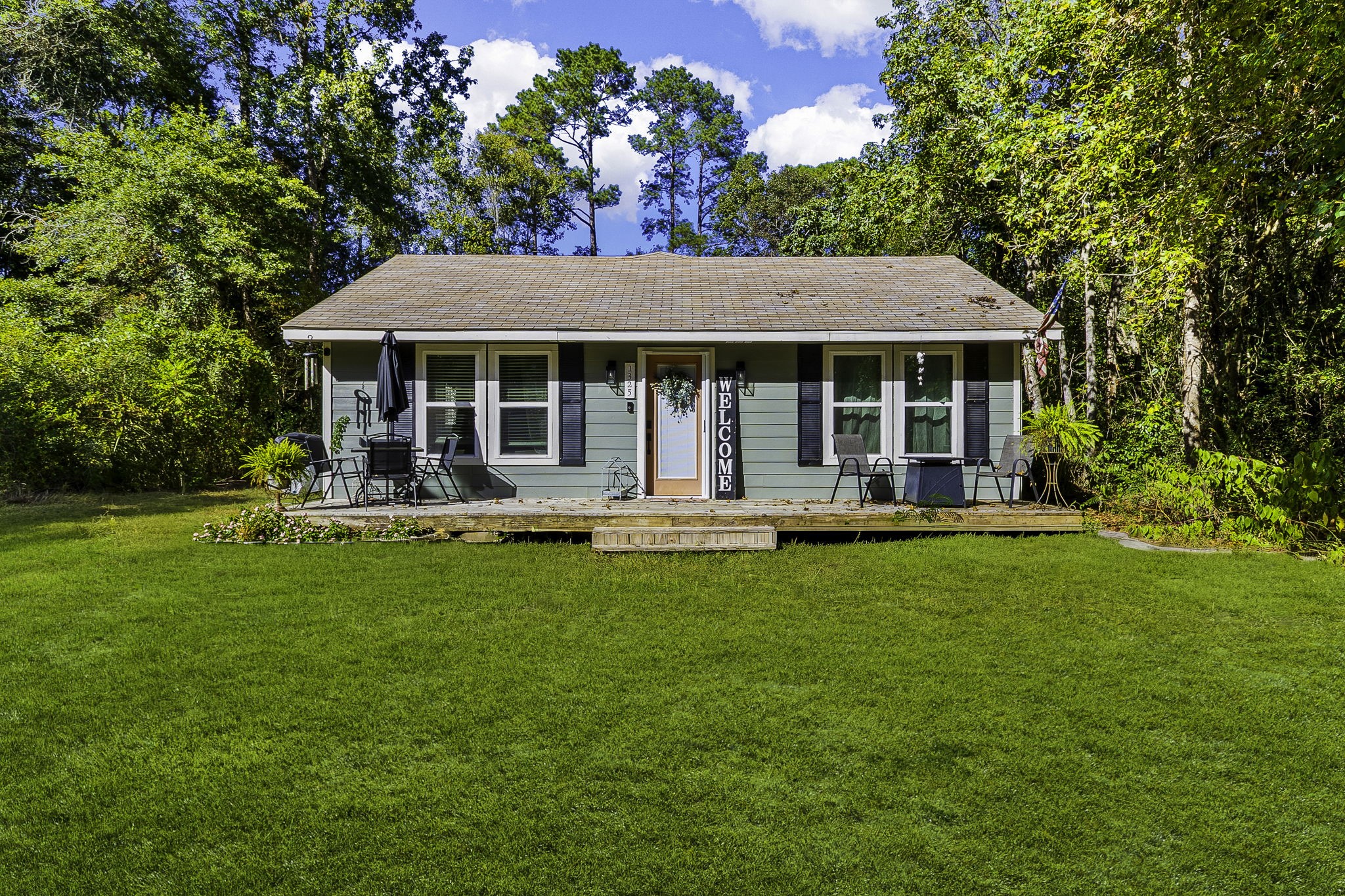 a front view of house with yard barbeque and outdoor seating