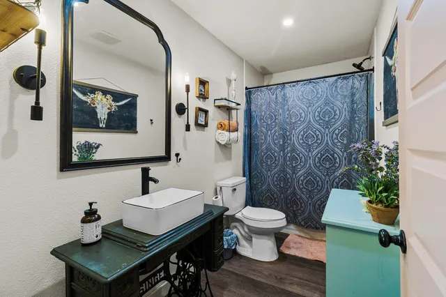 a bathroom with a toilet a sink and a mirror