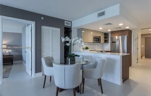 a dining room with furniture and a view of kitchen