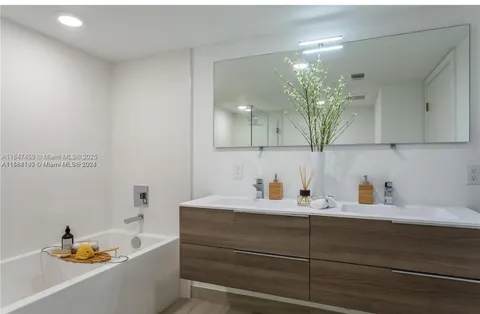 a bathroom with a tub sink and mirror