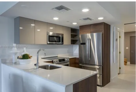 a kitchen with stainless steel appliances a refrigerator sink and microwave