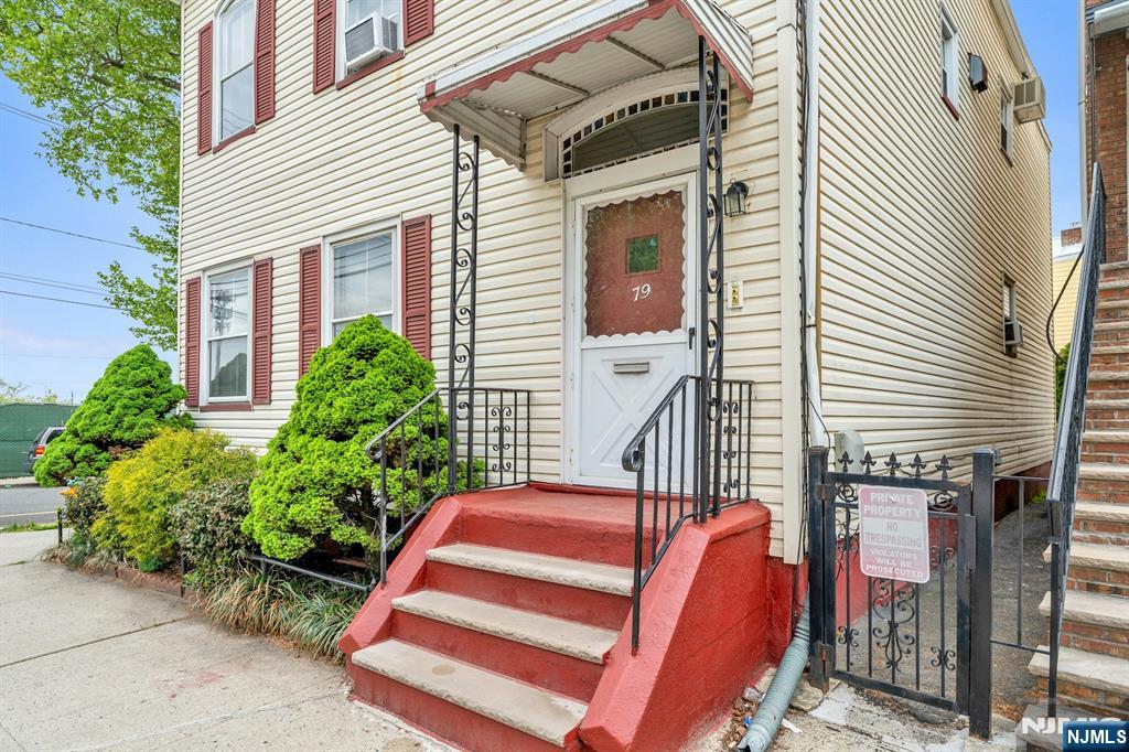 79 Washington Street Harrison, NJ 07029 - Photo 2 of 25 a front view of a house with a garden