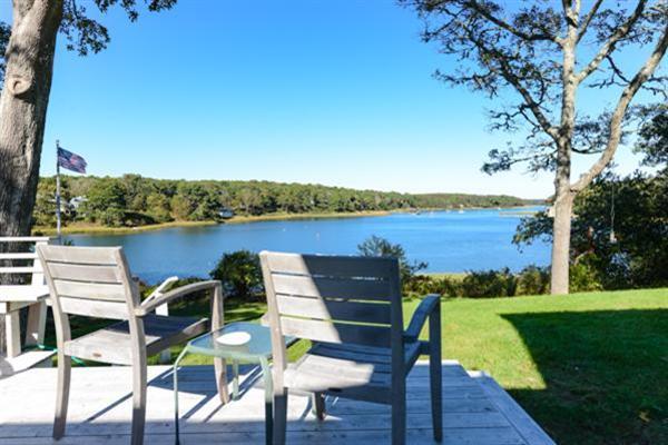 a view of a lake with table and chairs