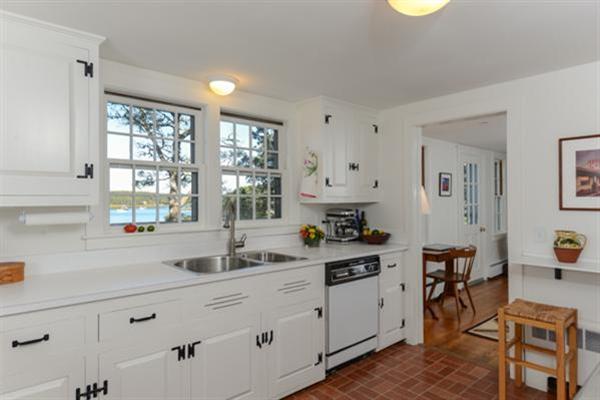 124 Namequoit Road Orleans, MA 02653 - Photo 11 of 30 a kitchen with white cabinets and window