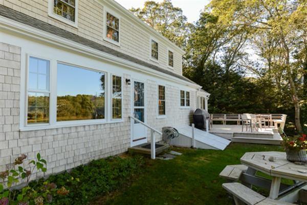 124 Namequoit Road Orleans, MA 02653 - Photo 27 of 30 a view of a house with backyard sitting area and garden