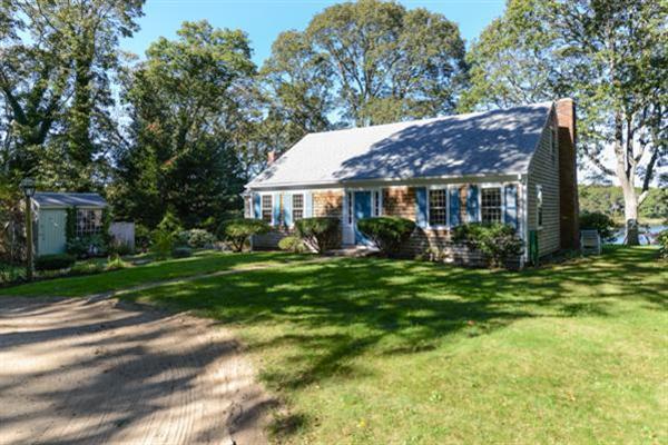 124 Namequoit Road Orleans, MA 02653 - Photo 29 of 30 a view of a house next to a big yard and large trees