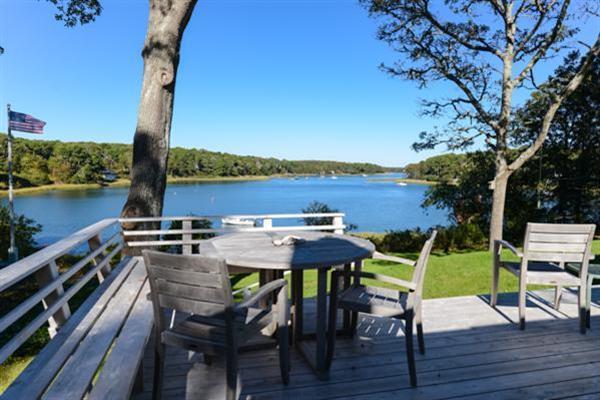 124 Namequoit Road Orleans, MA 02653 - Photo 6 of 30 a view of a chairs and table on wooden deck with lake view