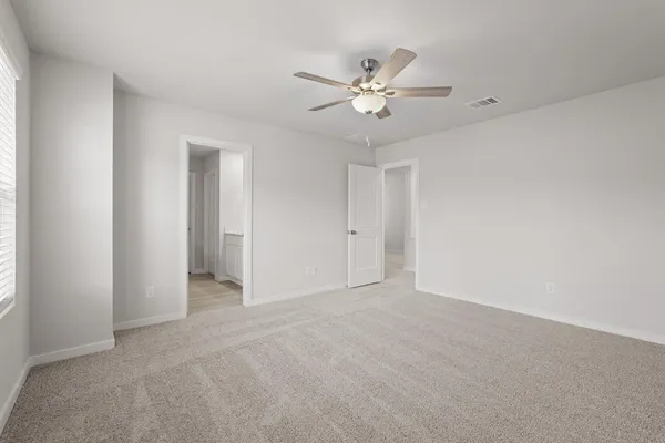 a view of an empty room with a chandelier fan