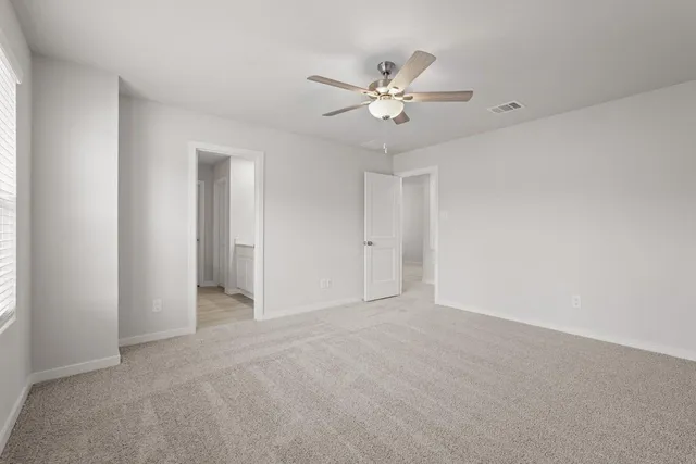 a view of an empty room with a chandelier fan