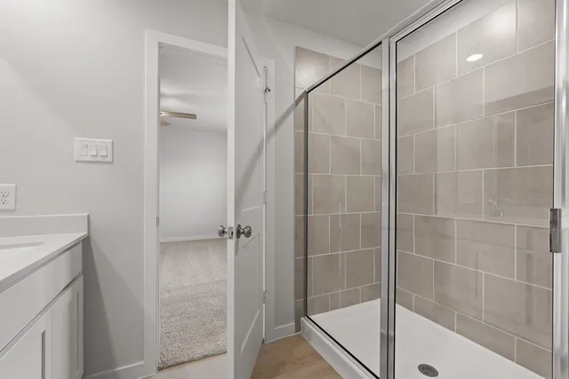 a bathroom with a shower and a glass door