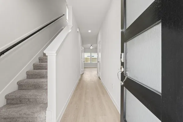 a view of a hallway with wooden floor and staircase