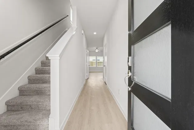 a view of a hallway with wooden floor and staircase
