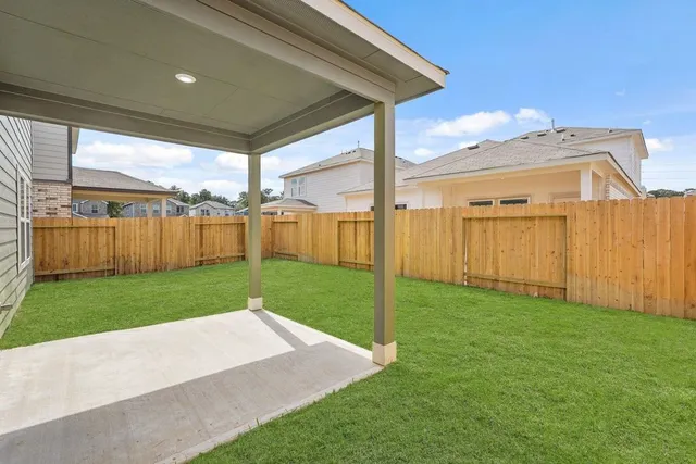 a view of a backyard with wooden fence