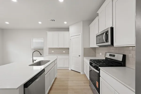 a kitchen with granite countertop a sink and cabinets