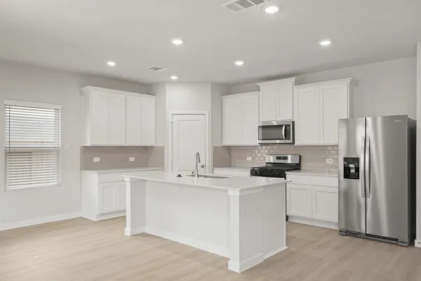 a kitchen with stainless steel appliances a refrigerator stove microwave and sink