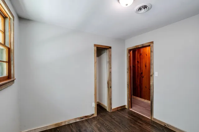 an empty room with wooden floor and a window