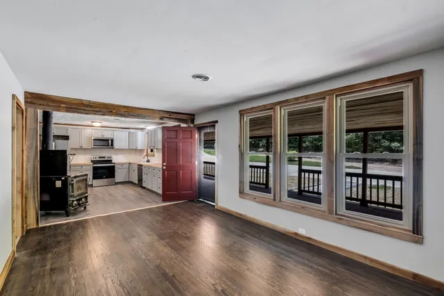 a view of a big room with wooden floor chandeliers and kitchen